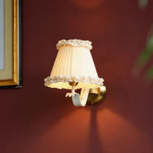Lit Chantal wall sconce with warm ambient light on burgundy accent wall creating cozy vintage atmosphere