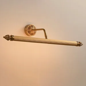 Chatsworth Acanthus brass wall sconce illuminated with warm light, showcasing ornate brass ends and classical design