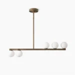 Chelso horizontal linear chandelier with five frosted glass globes and brushed antique brass frame, overhead studio view