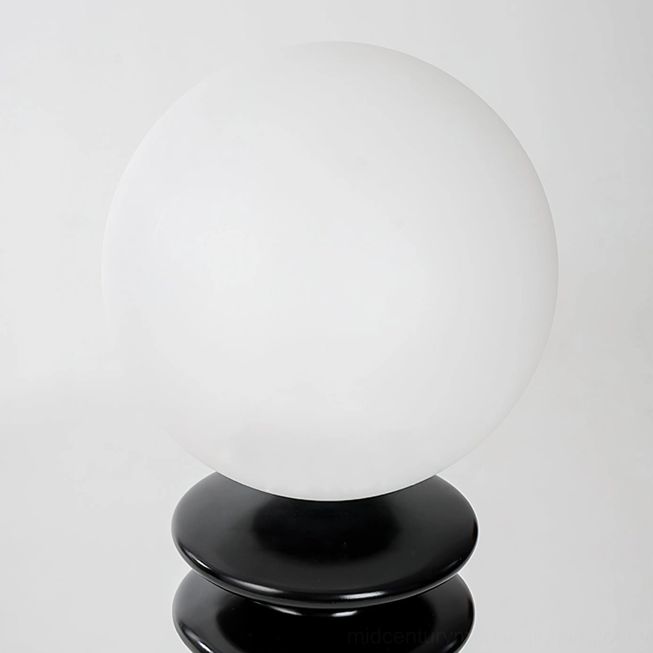 Close-up detail of chess floor lamp frosted glass head and multi-layered black base
