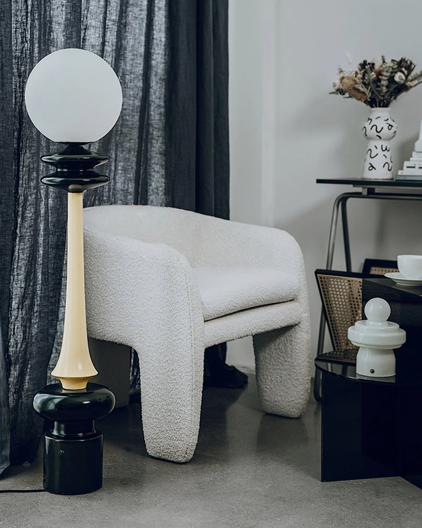 Chess floor lamp side profile in living room with boucle ottoman and neutral tones