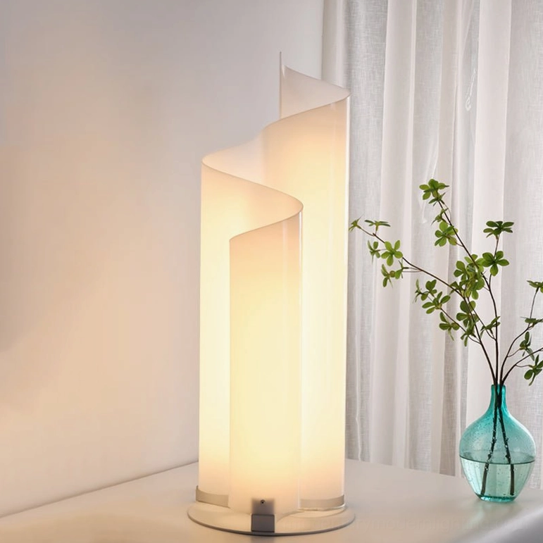 Close-up detail of chimera lamp frosted acrylic twisted shade and silver metal base by window with warm light diffusion
