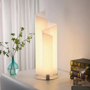 Illuminated chimera spiral lamp in living room beside sheer curtains creating warm ambient glow with books and blue glass vase