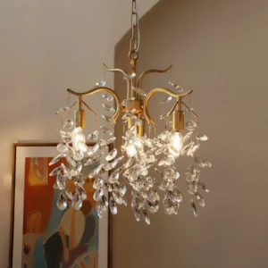Brass crystal leaf chandelier hanging in vintage mid-century living room with warm glowing Edison bulbs and curved branching arms