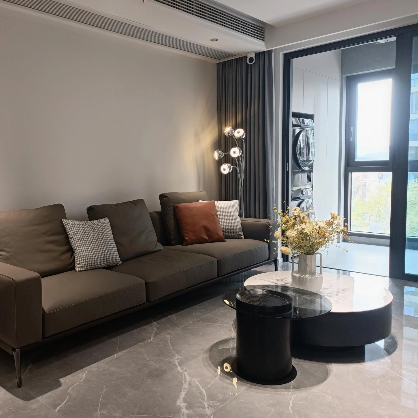 Multi-head chrome eyeball floor lamp in spacious modern living room with warm ambient lighting and fabric sofa