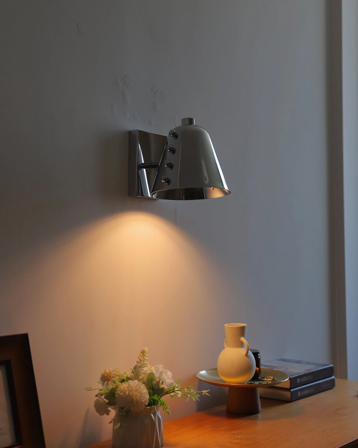 Chrome wall lamp in luxury modern interior with marble surfaces and premium textiles