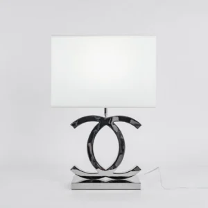 Contemporary chrome table lamp with white fabric dome shade, clean studio lighting showing polished metal finish and geometric form