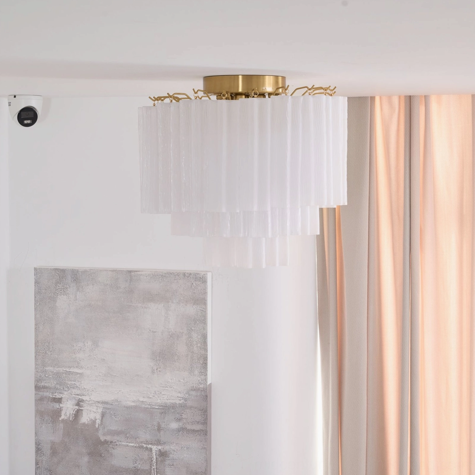 Wide side view of Chrono Tubular Ceiling Lamp with prominent brass ceiling fixture and white lamp body against wall art