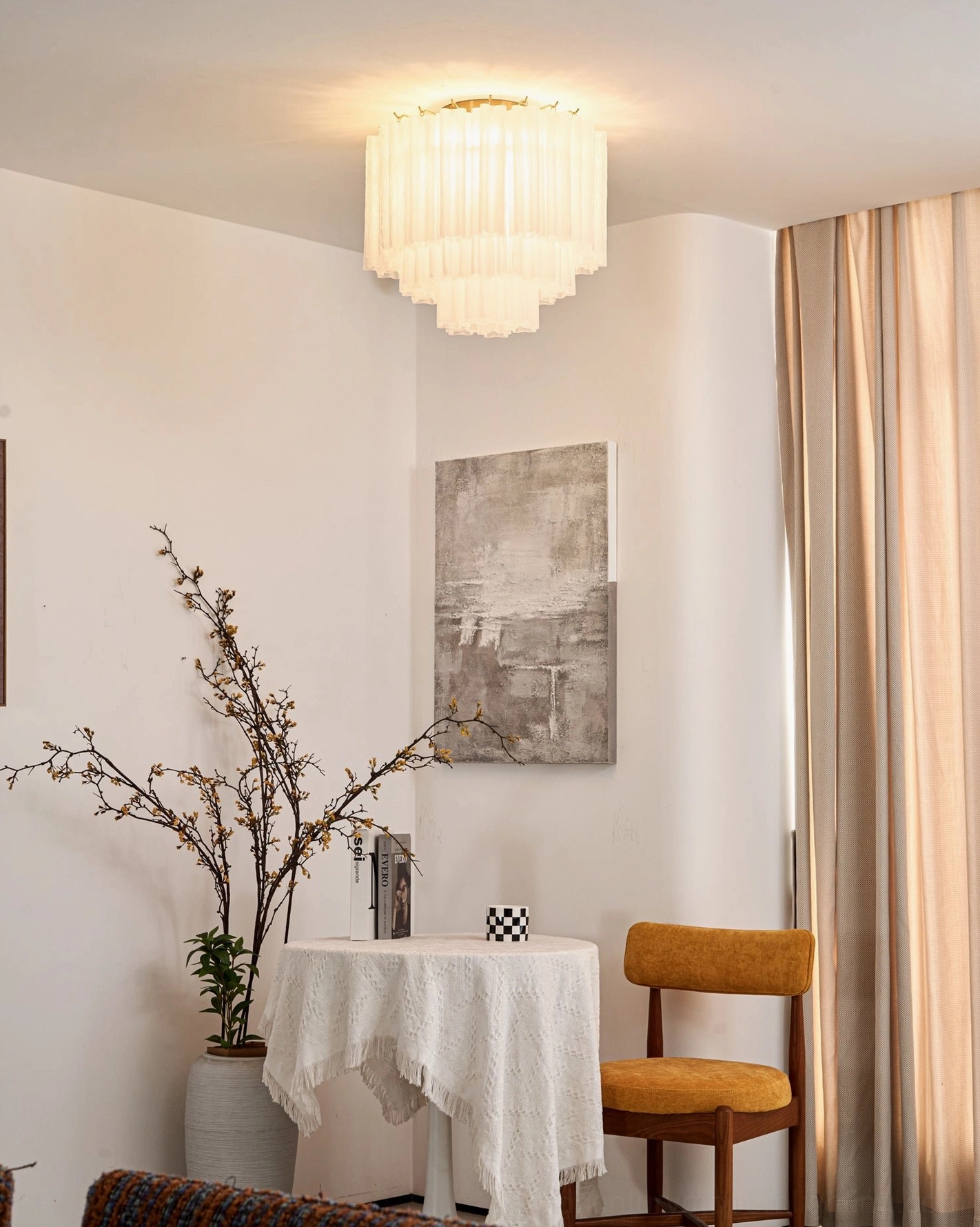 Lit Chrono Tubular Ceiling Lamp in warm-toned dining room emitting soft ambient light through layered fluted design