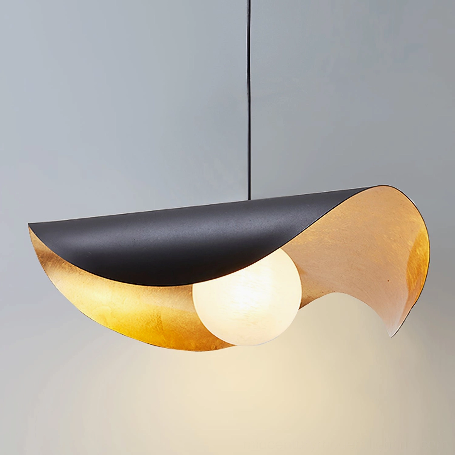 Cilla asymmetrical pendant lamp close-up front detail, sleek curved silhouette, opal frosted glass light source on light gray background