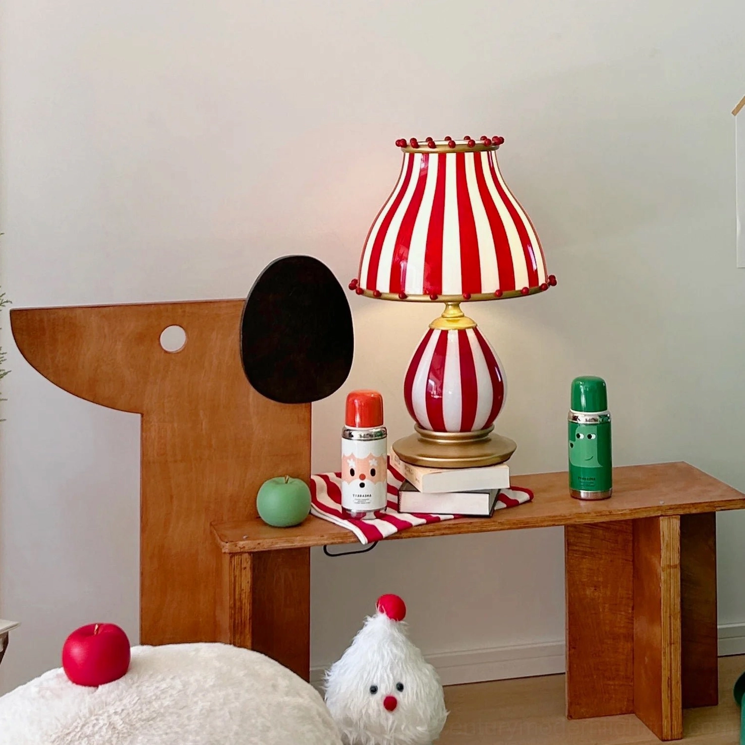 Vintage circus striped lamp on wooden desk with decorative ornaments and accessories