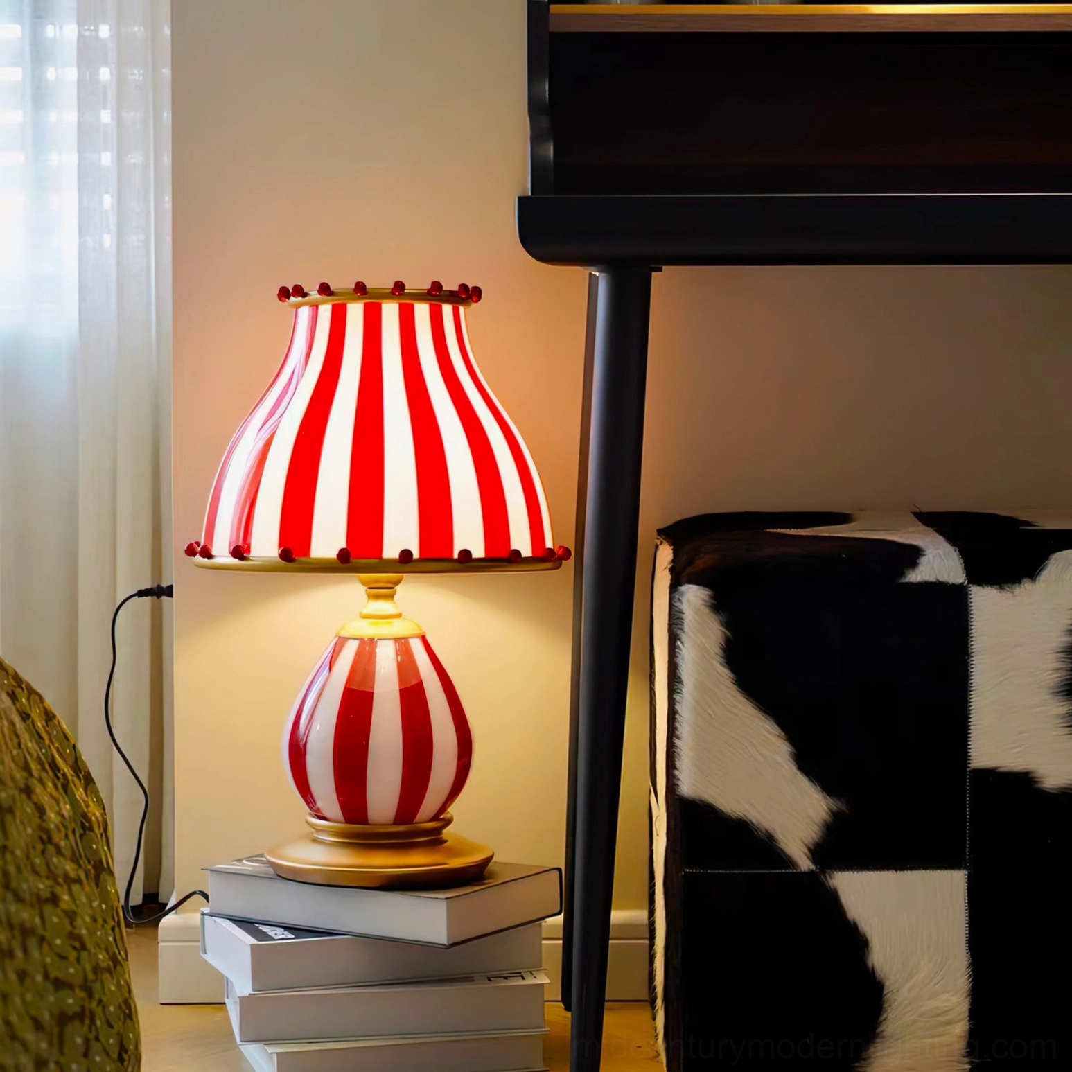 Striped vintage circus lamp positioned on stacked books under piano in home living space