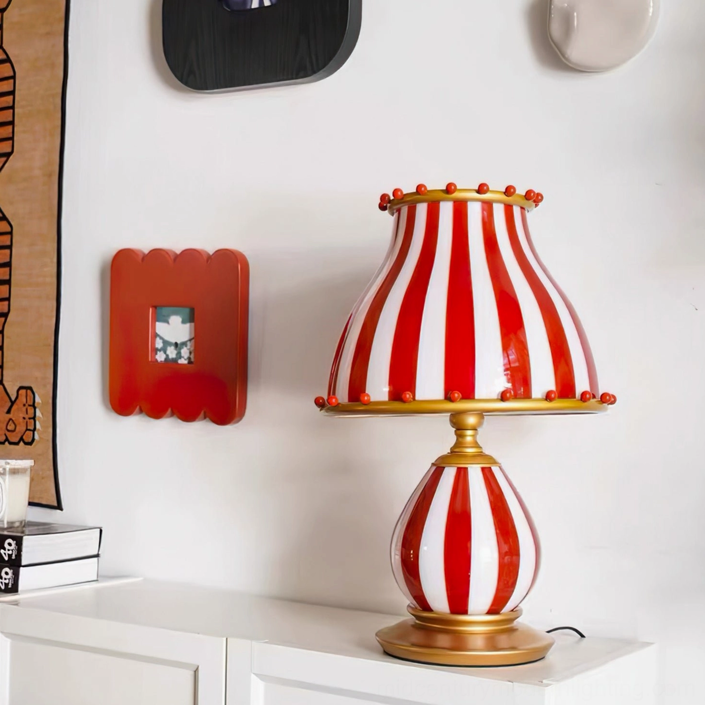Red and white striped circus carnival table lamp displayed on home cabinet with wall art