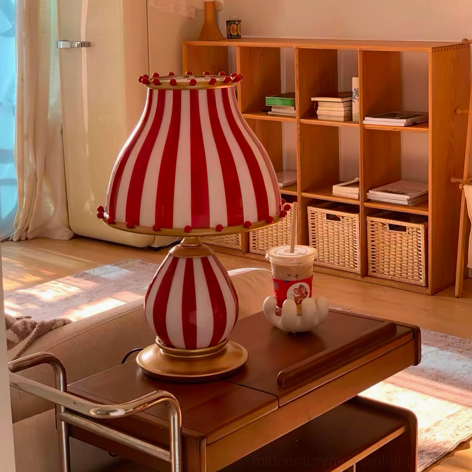 Red and white carnival-inspired table lamp on living room end table with coffee cup décor
