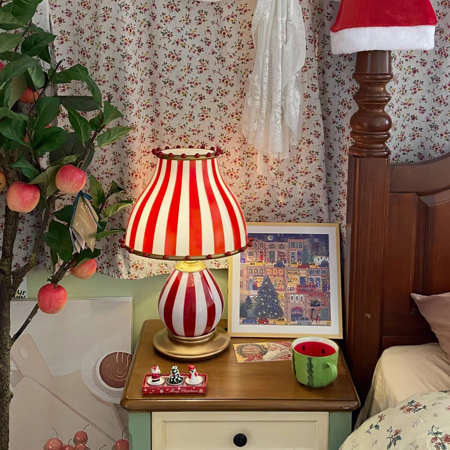 Circus striped lamp on bedroom nightstand with floral wall art and fruit decor styling