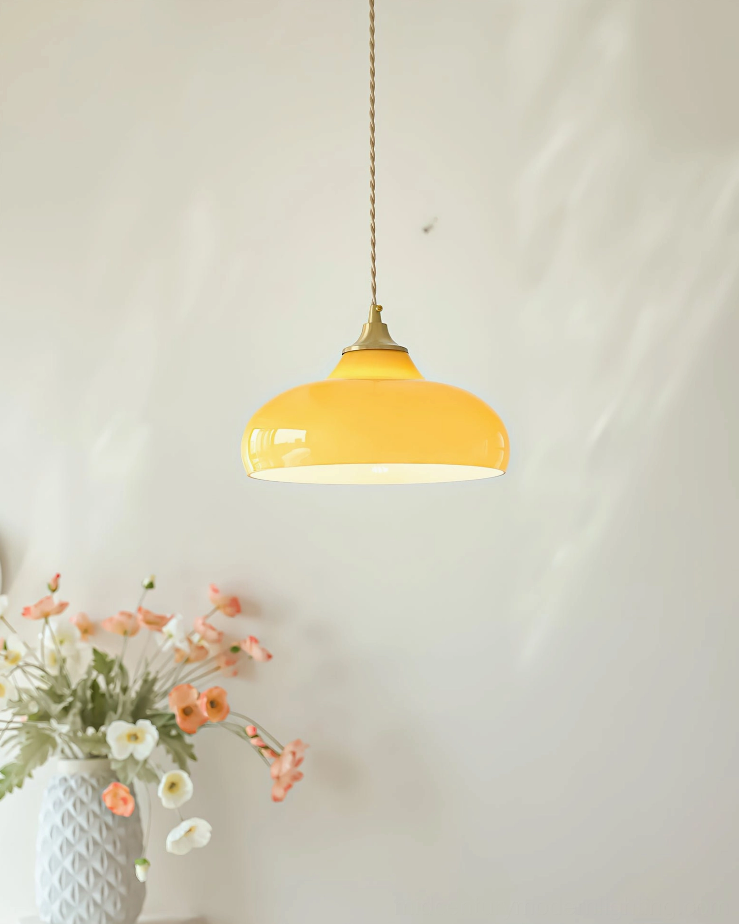 Citrine dome pendant lamp creating soft warm overhead glow in cozy interior with flower vase