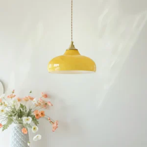 Citrine yellow dome pendant glowing warm in mid-century modern interior with floral decor and woven wall hanging