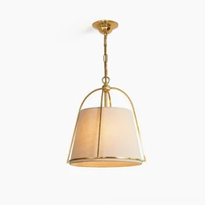 Clarke mid-century modern pendant light with tapered brass frame and beige linen shade, front studio view