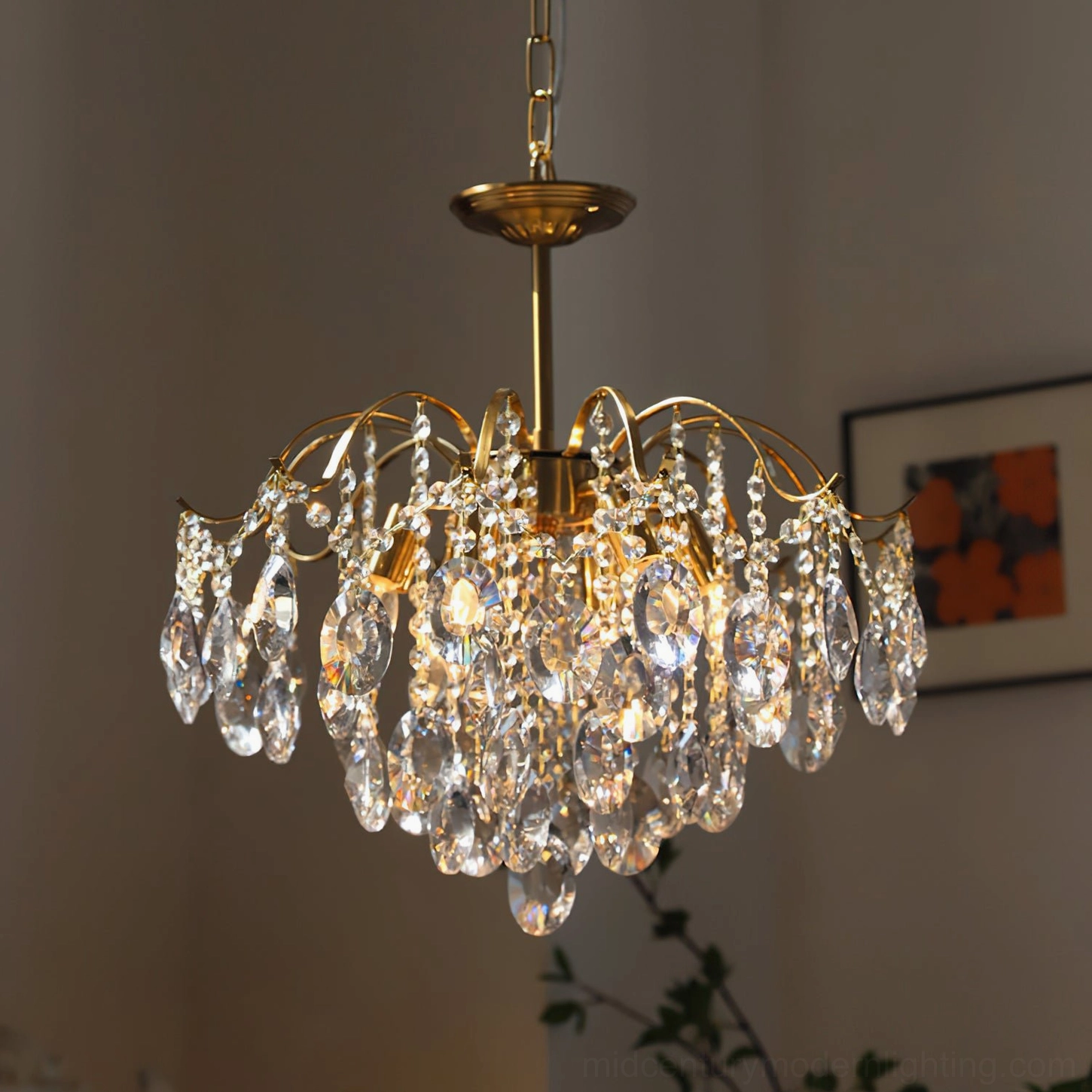 Clear crystal chandelier three-quarter view glowing with lit bulbs, layered crystal design in cozy interior with green plants