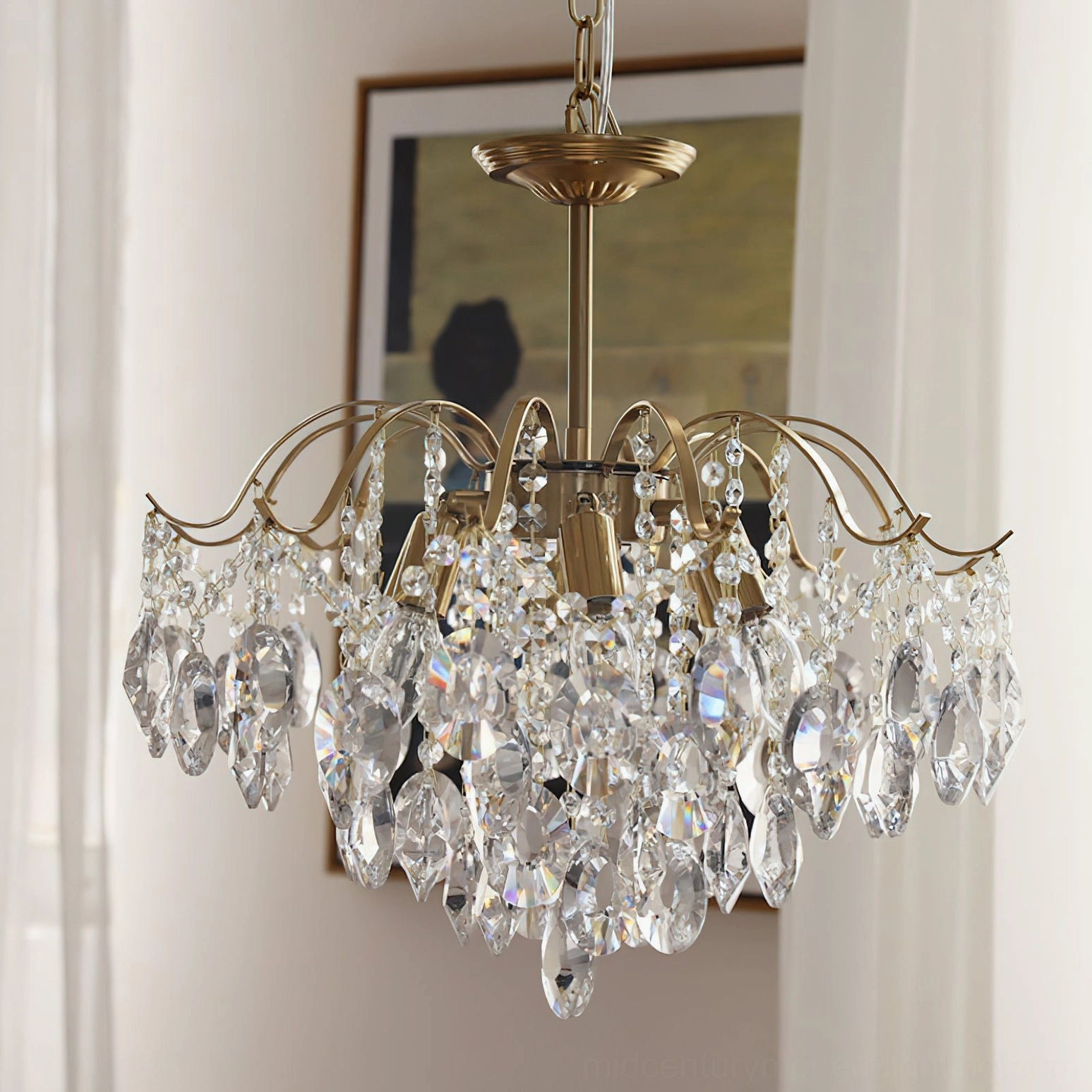 Clear crystal waterfall chandelier with brass frame, transparent teardrop crystals and polished gold-tone hardware detail