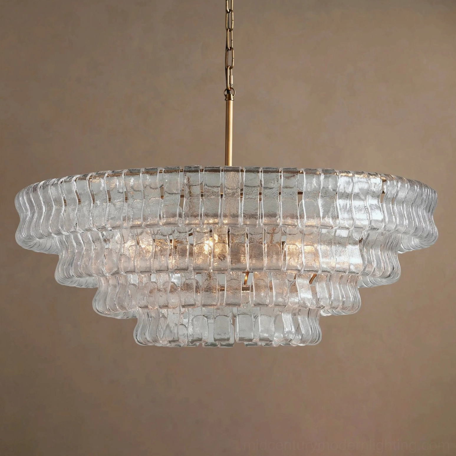 Clear tiered crystal chandelier with bright internal illumination and polished brass frame, frontal flat view detail