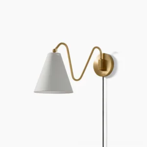 Cleome swing arm wall lamp with brass curved arm and white fabric shade on white background studio shot