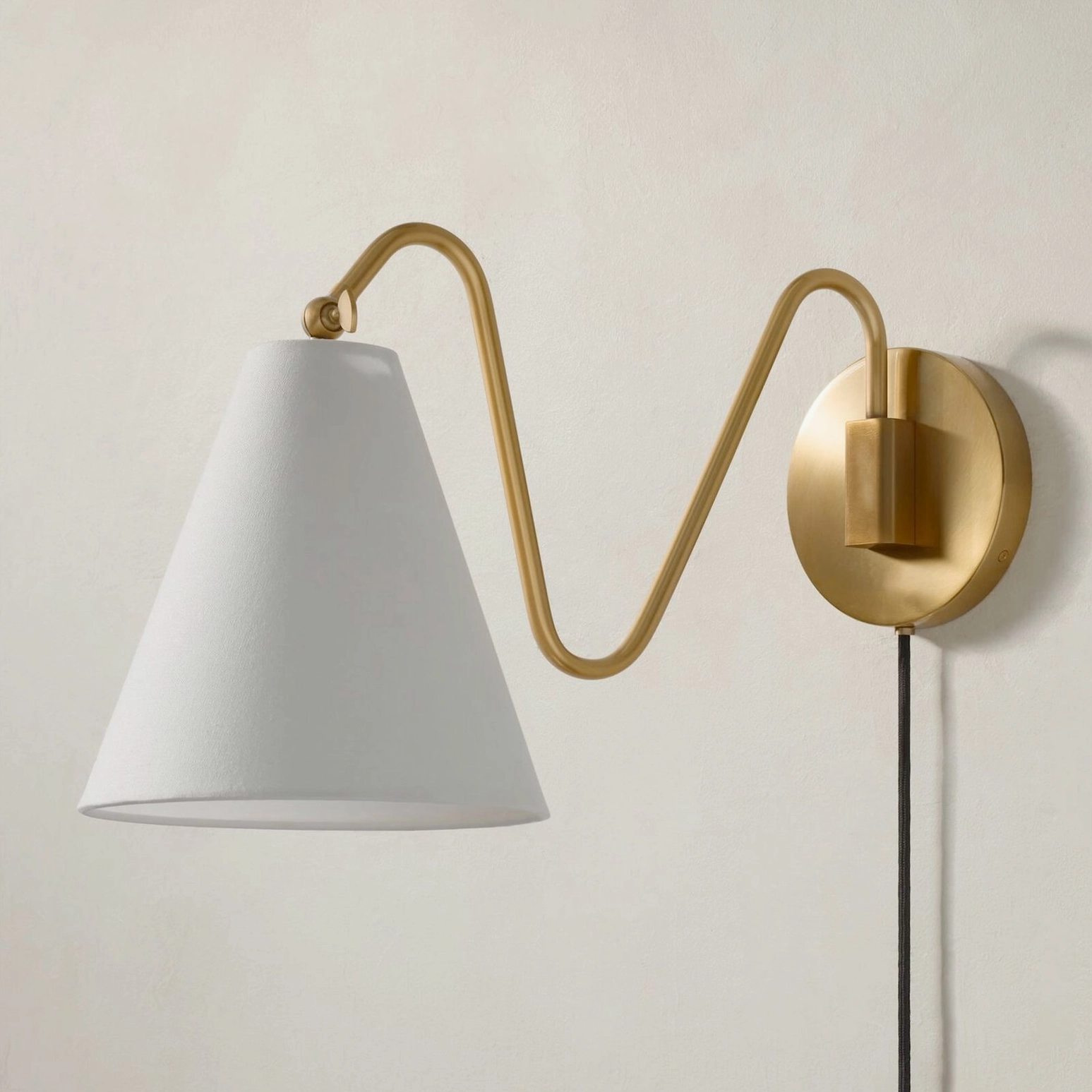 Side view swing arm plug-in wall lamp brass round base white conical shade exposed cord