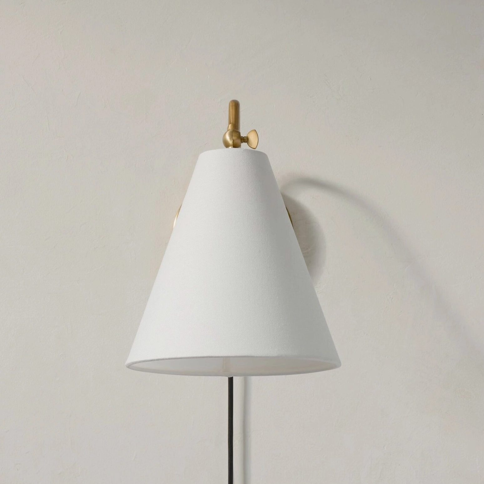 Cleome swing arm wall lamp three-quarter view brass finish white shade plug-in design