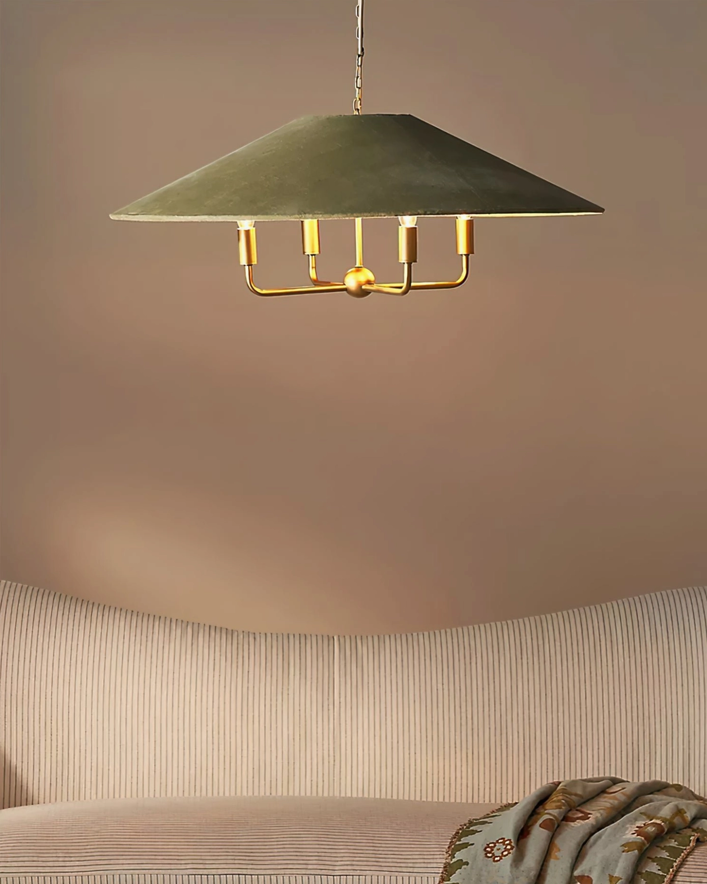 Clivedon pendant lamp suspended over modern sofa with minimalist conical shade profile
