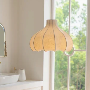 Beige cocoon pendant lamp hung in contemporary bathroom with natural daylight, soft warm ambient lighting near vanity