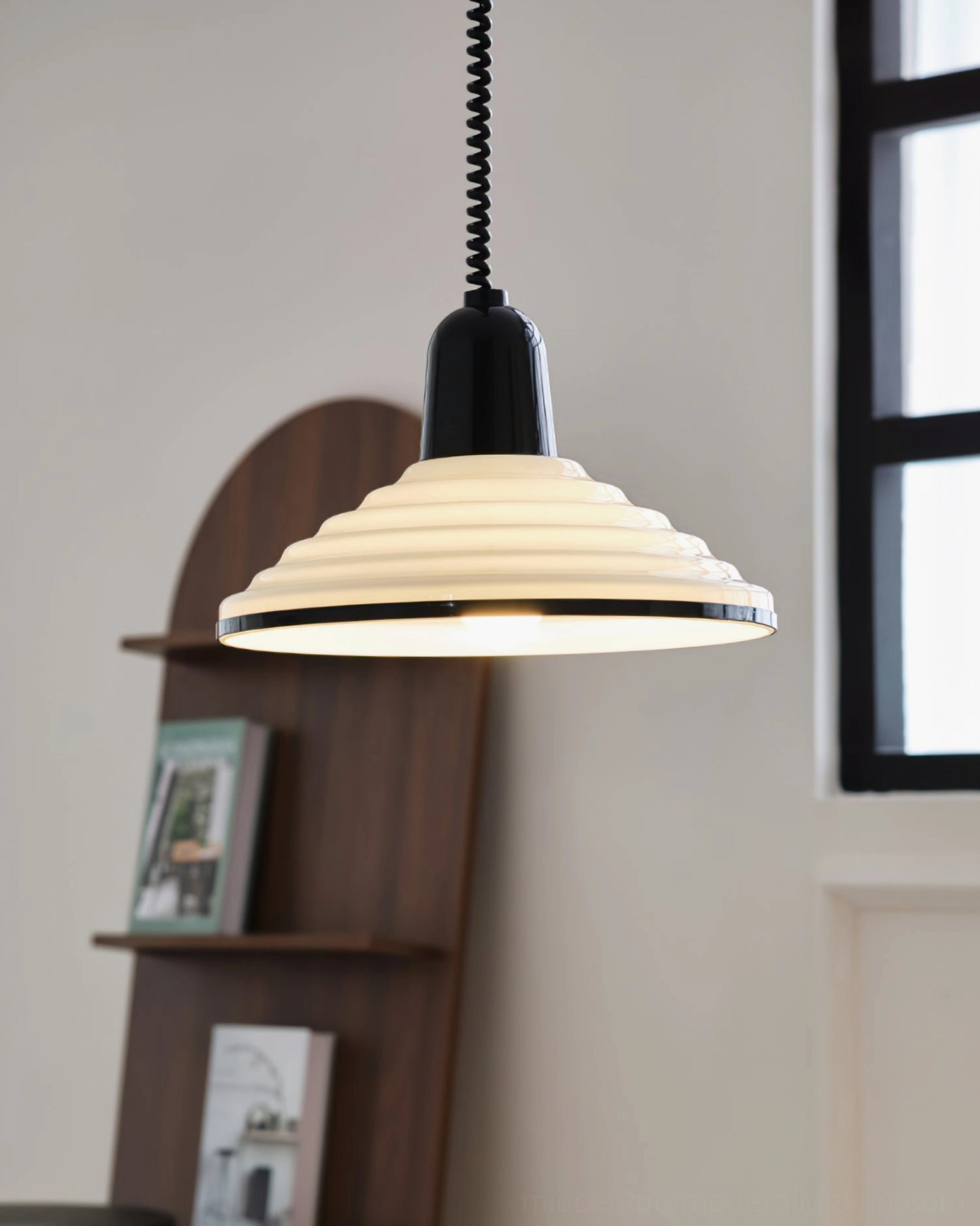 Illuminated ridged pendant lamp three-quarter view home interior wooden bookshelf ambient lighting