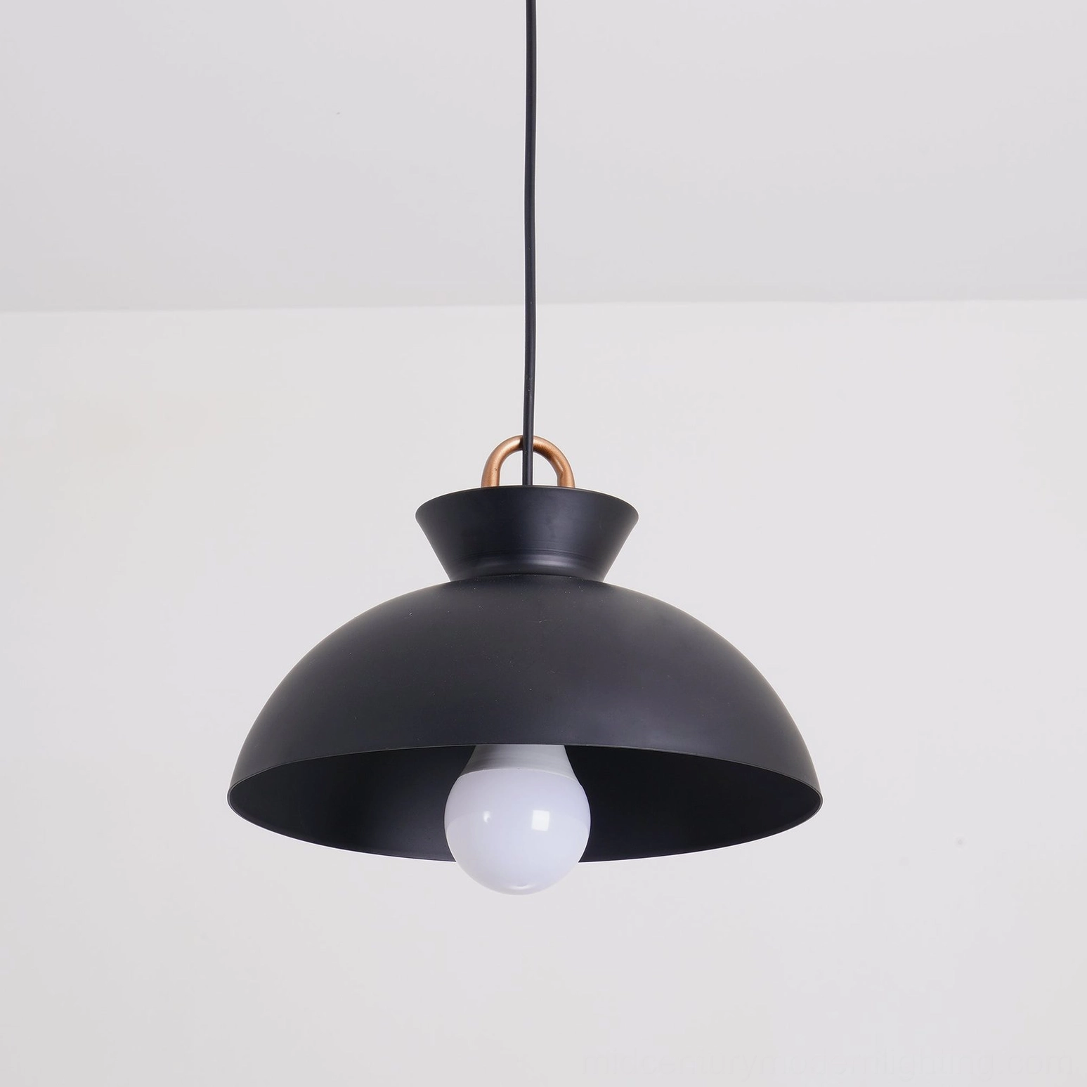Coil pendant light with exposed bulb creating contemporary geometric shadow patterns