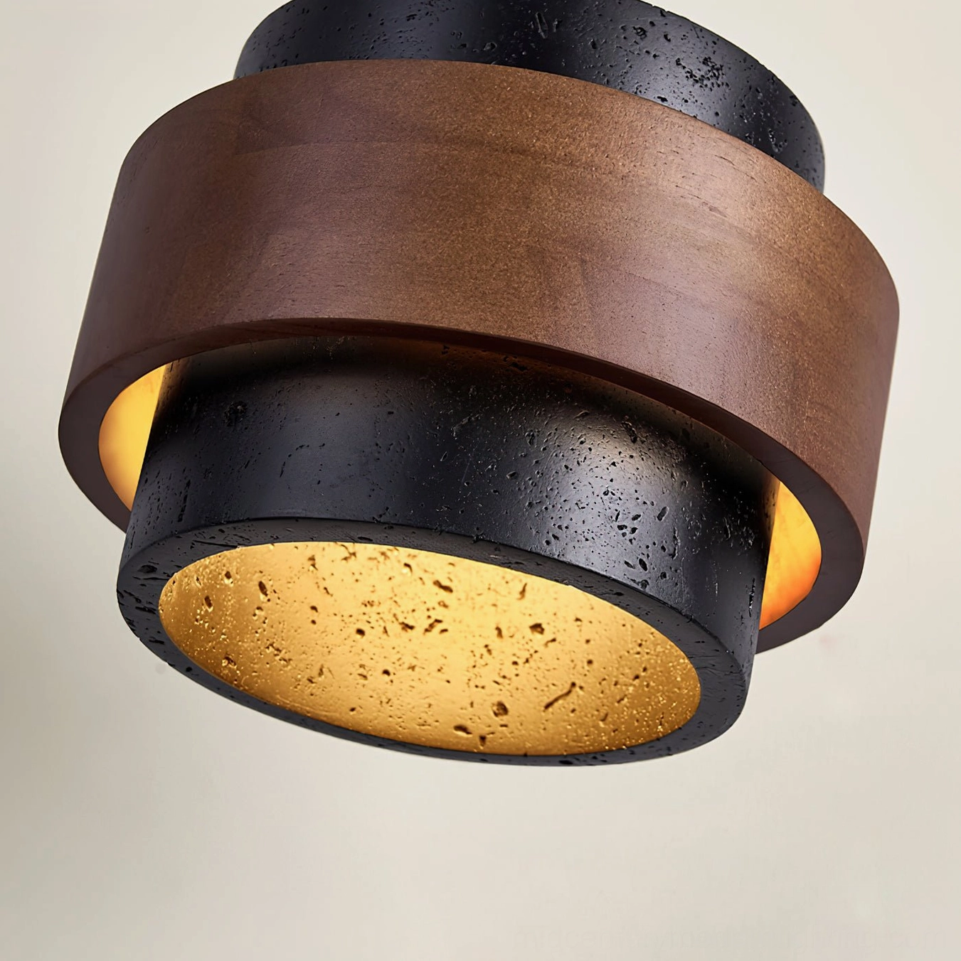 Cole Travertine light fixture low-angle front view revealing layered wood and stone ring design with warm glow