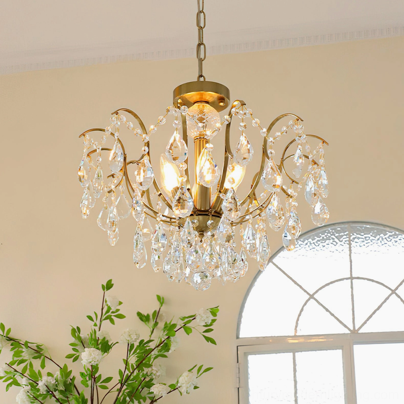 Close-up front view of Colette Crystal Chandelier's faceted crystal pendants and curved brass framework