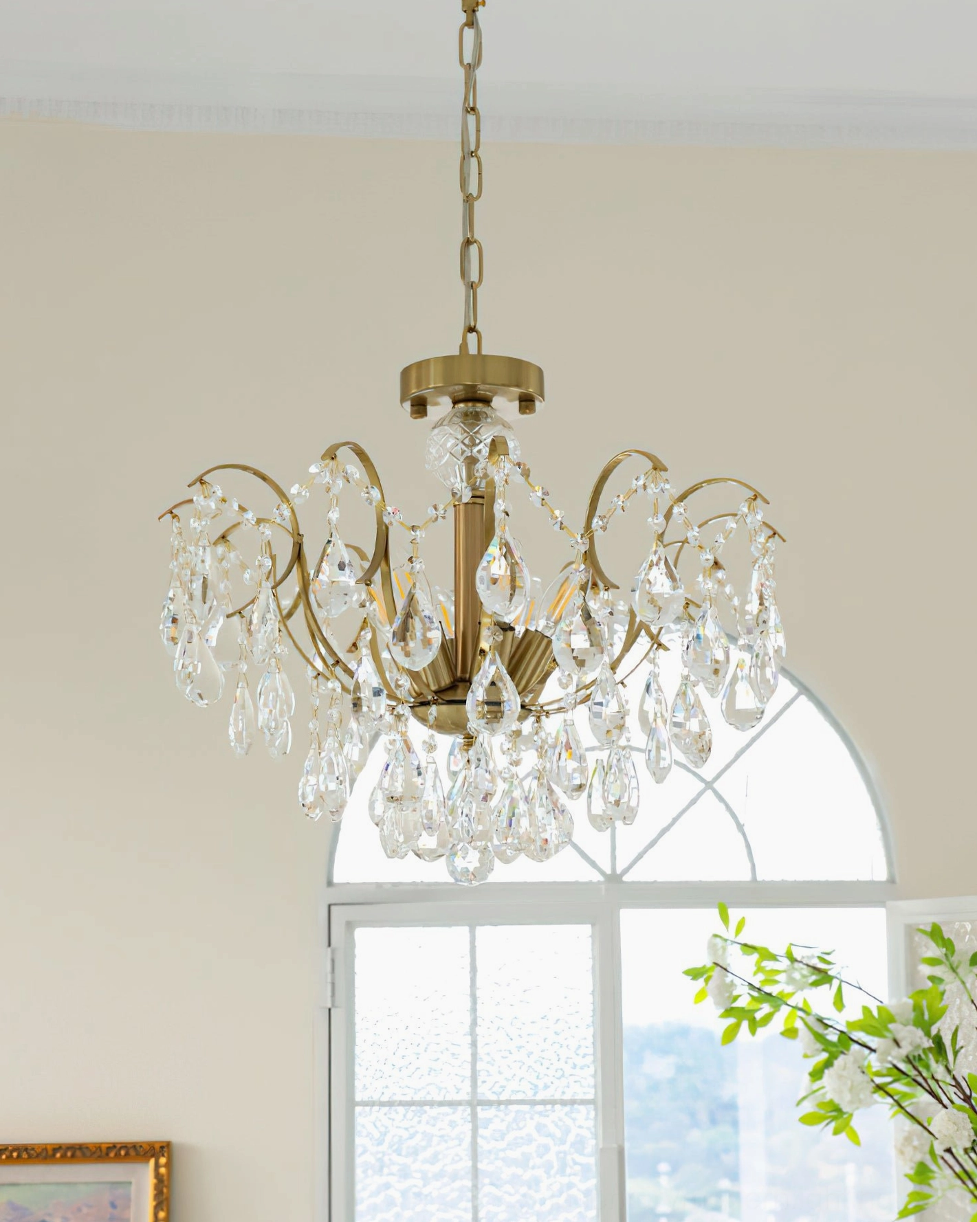 Colette Chandelier detail shot highlighting faceted crystal droplets and curved brass frame architecture