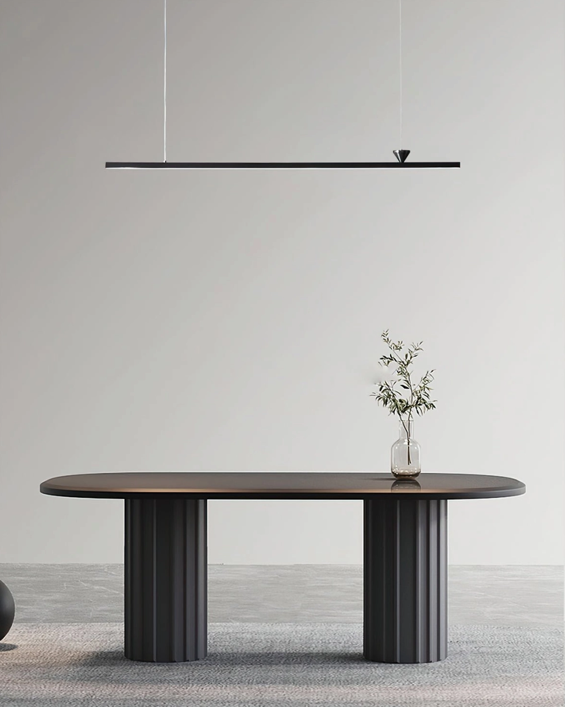 Sleek black linear hanging light above minimalist round dining table