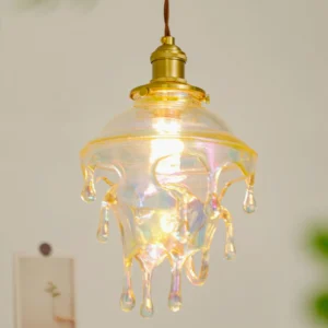 Colored glazed resin drip pendant with warm ambient light illuminating iridescent glass and brass hardware