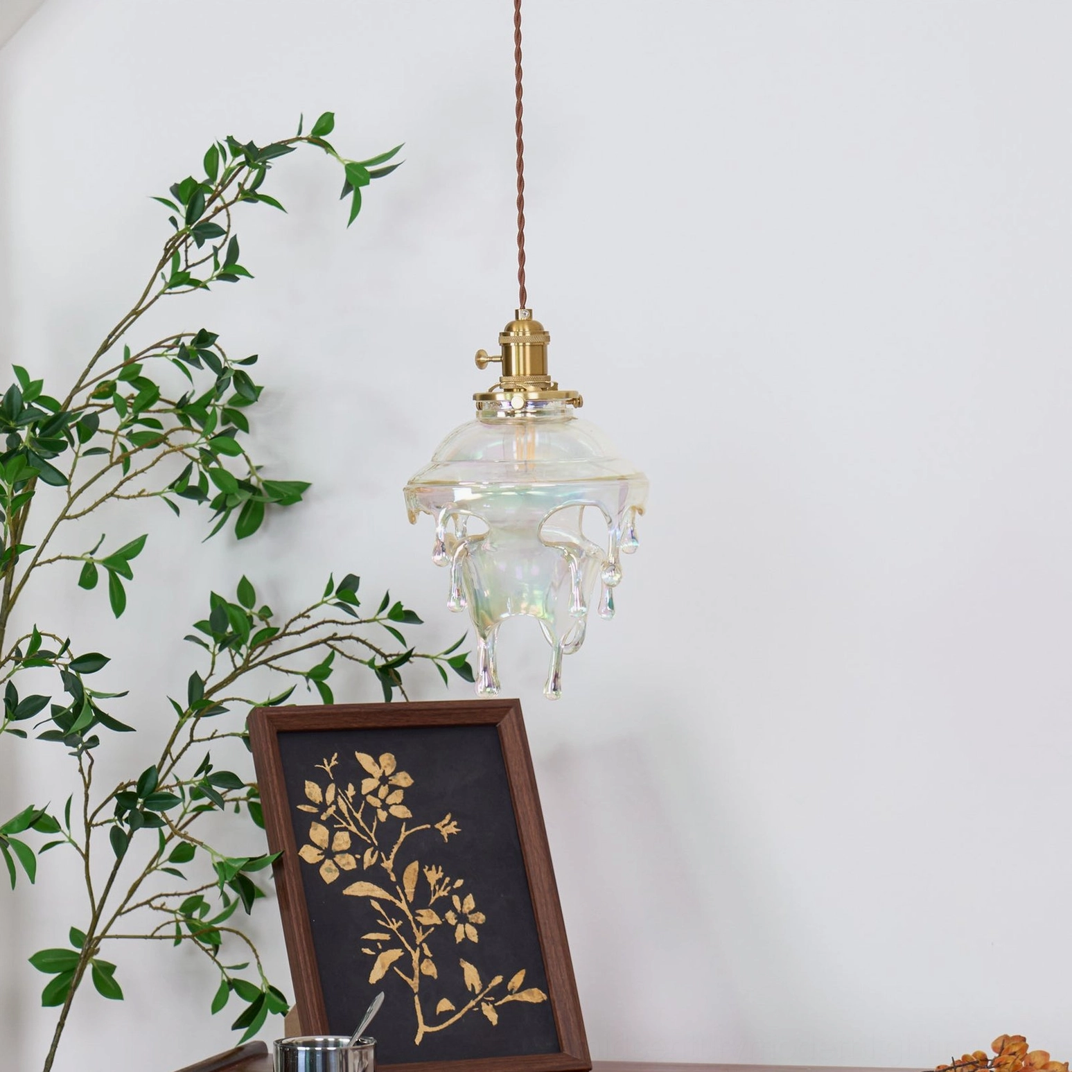 Colored glazed water droplets pendant refracting warm light with iridescent glow effects