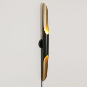 Coltrane compact wall lamp on white wall, plug-in cord visible, modern geometric silhouette