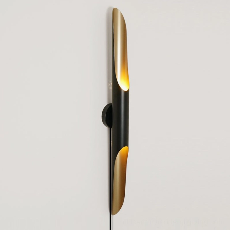 Coltrane compact wall lamp on white wall, plug-in cord visible, modern geometric silhouette
