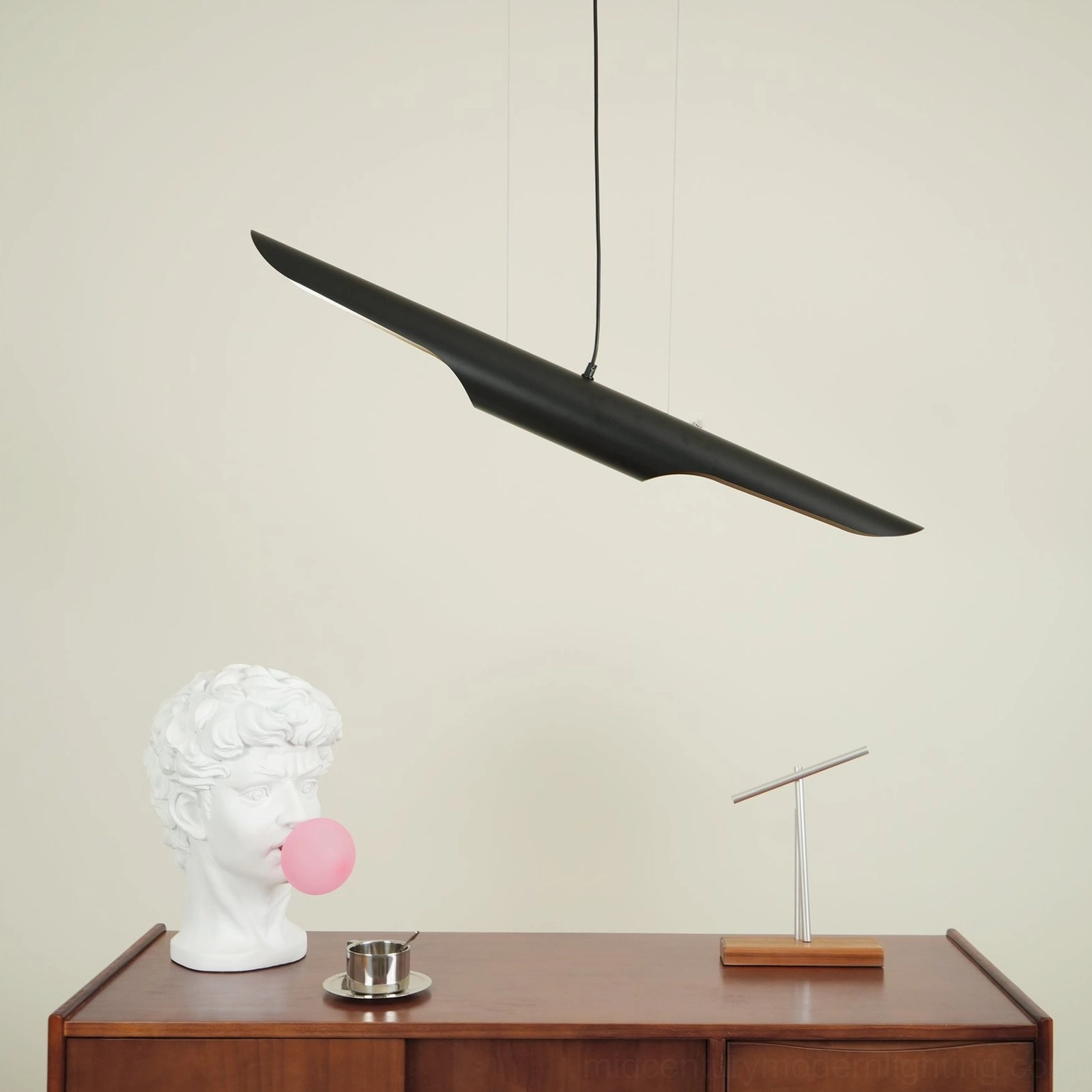 Coltrane pendant lamp installed over wooden workspace with warm ambient lighting effect