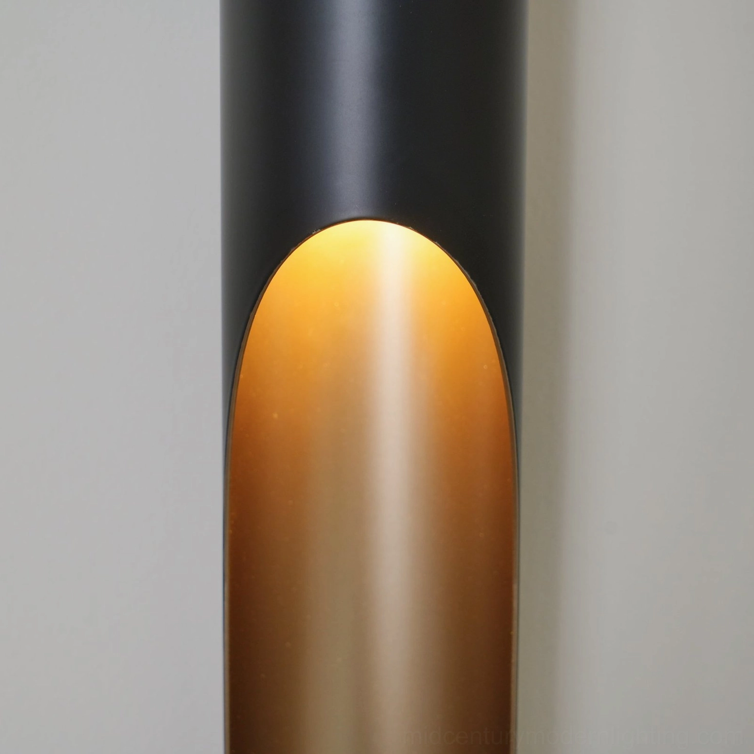 Coltrane wall sconce close-up showing arched light opening and warm ambient glow detail