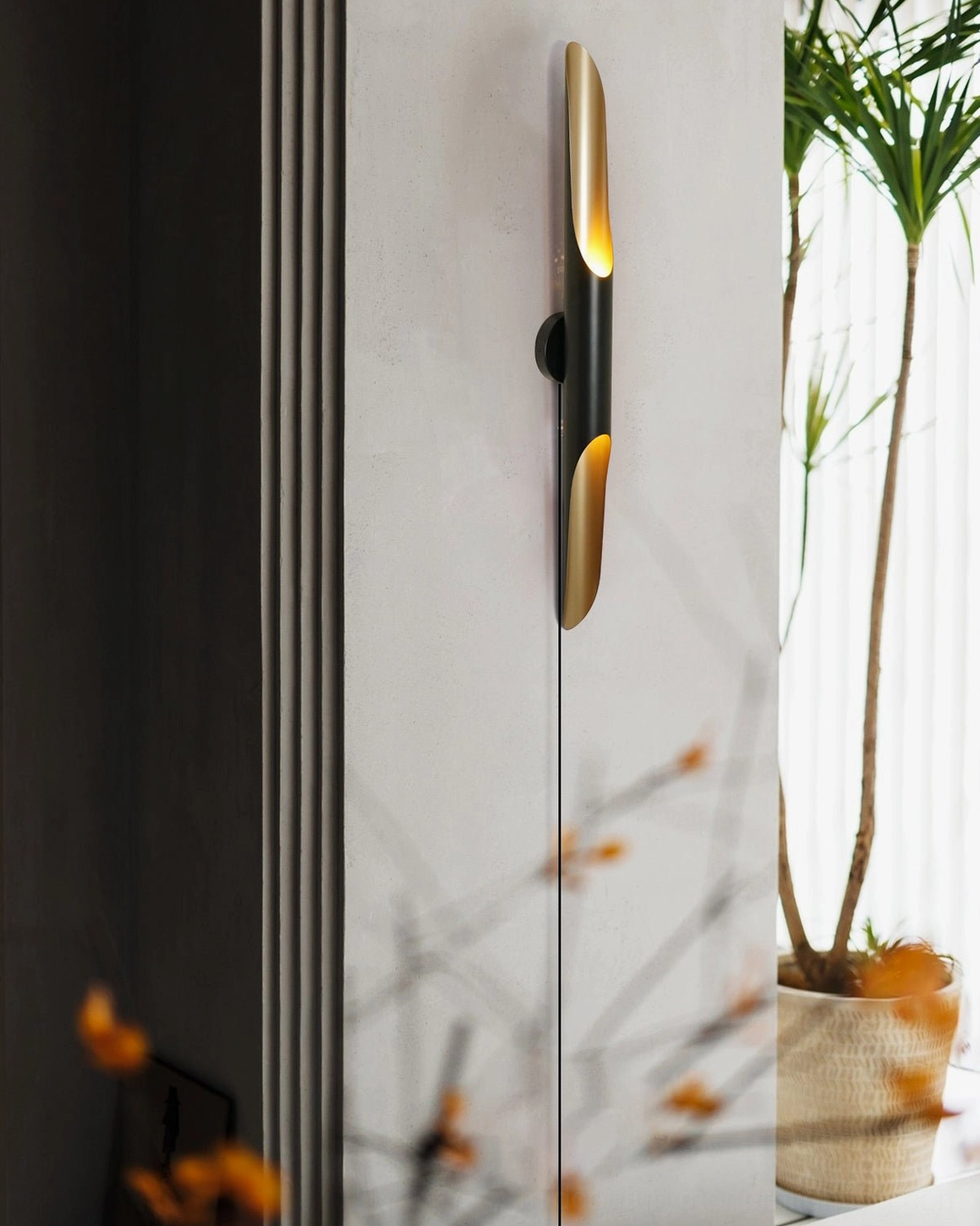 Coltrane wall sconce in modern entryway with potted plant, minimalist interior design