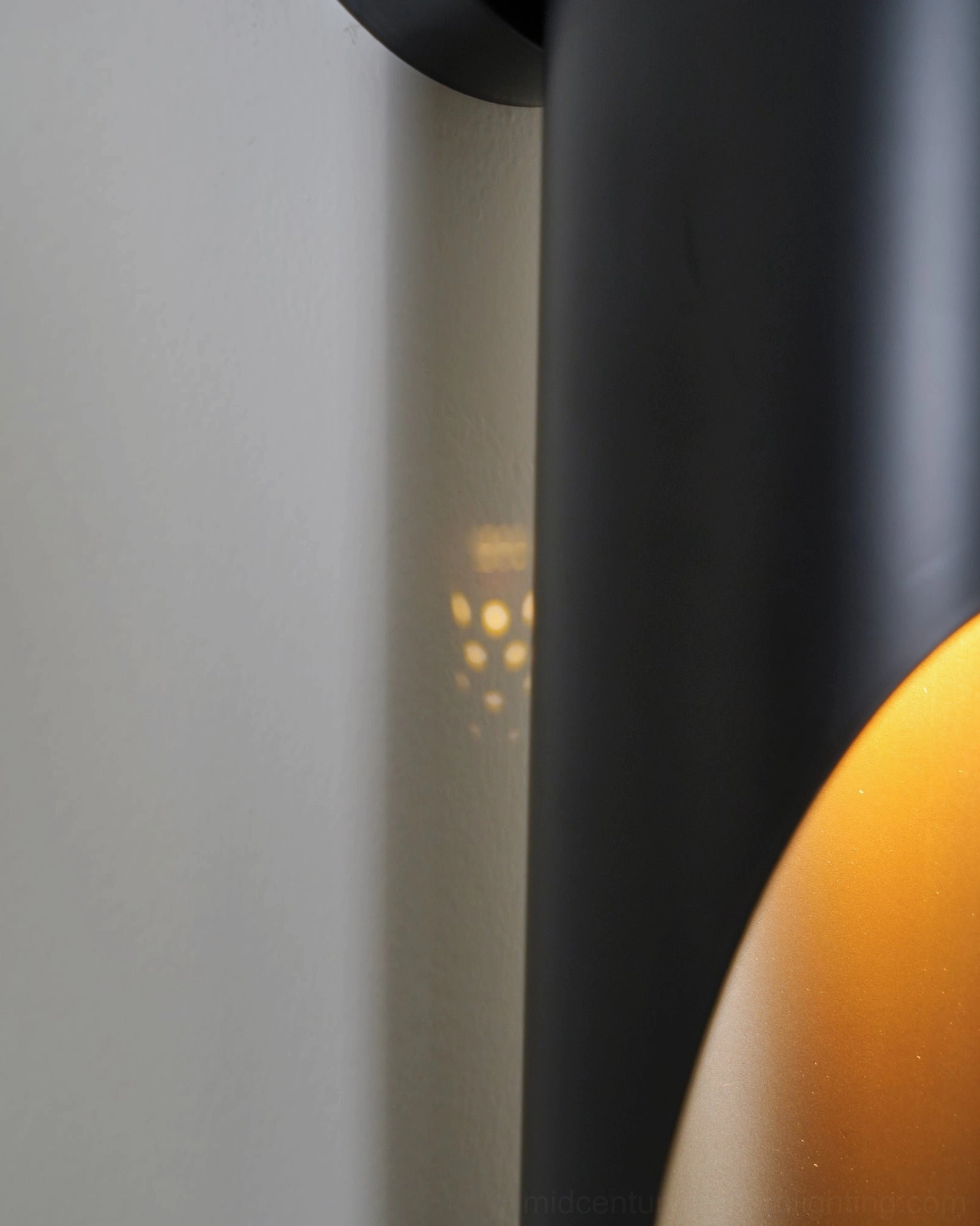 Coltrane minimalist wall lamp side angle view matte black finish soft ambient lighting