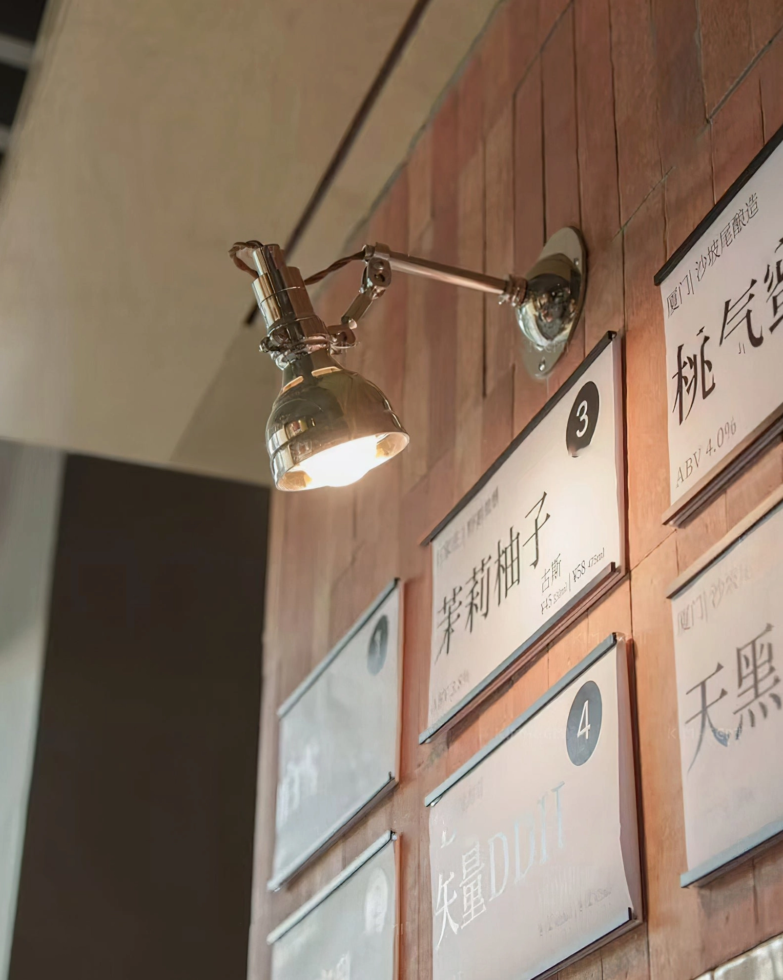 Compact swing arm wall lamp mounted at eye level, polished silver fixture in modern interior space