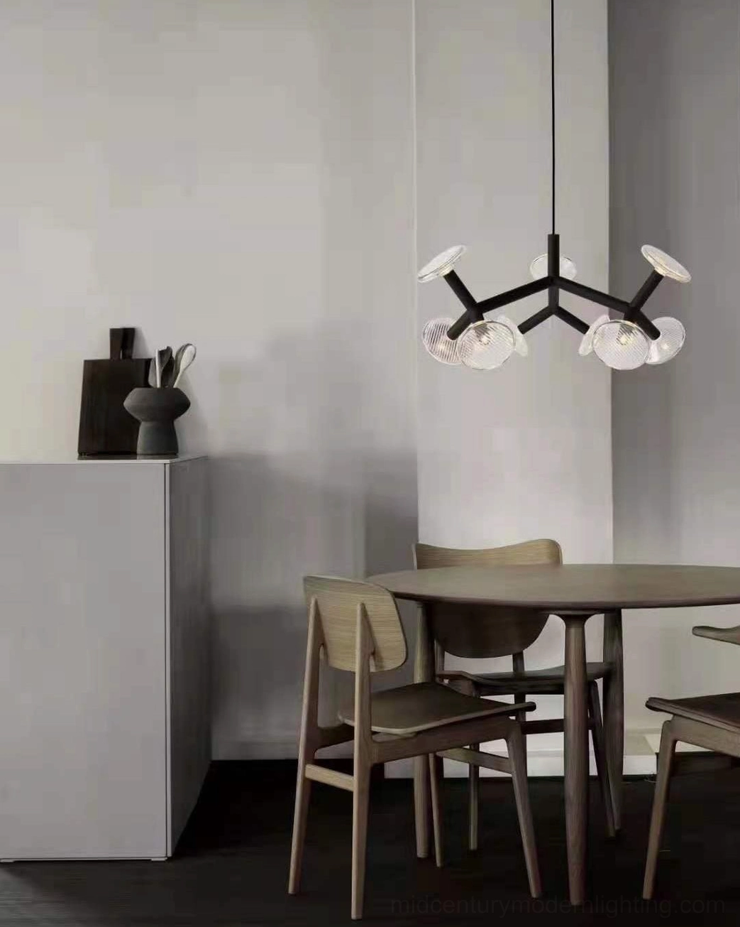 Compact matte black 3-head fractal chandelier with ribbed glass shades in dining space