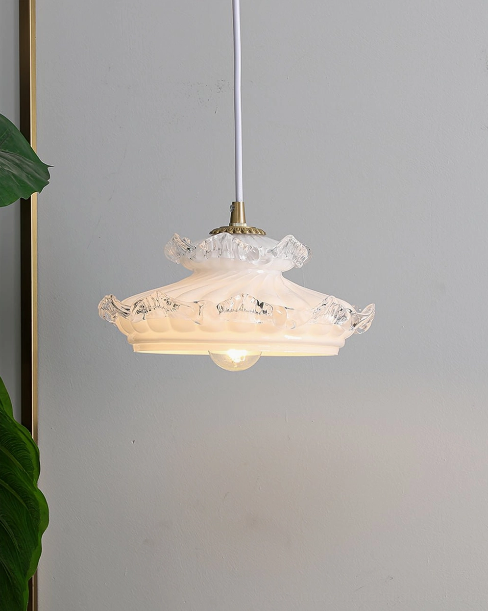 Compact vintage pendant lamp with white hanging cord and brass hardware on neutral grey wall