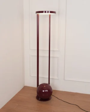 Burgundy composition floor lamp in contemporary corner setting with wood flooring and paneled walls - unlit ambient view