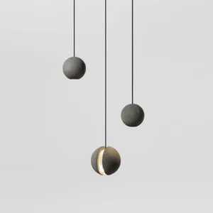 Set of concrete pendant lights hanging from above, mixed solid and split spherical designs with black suspension cords
