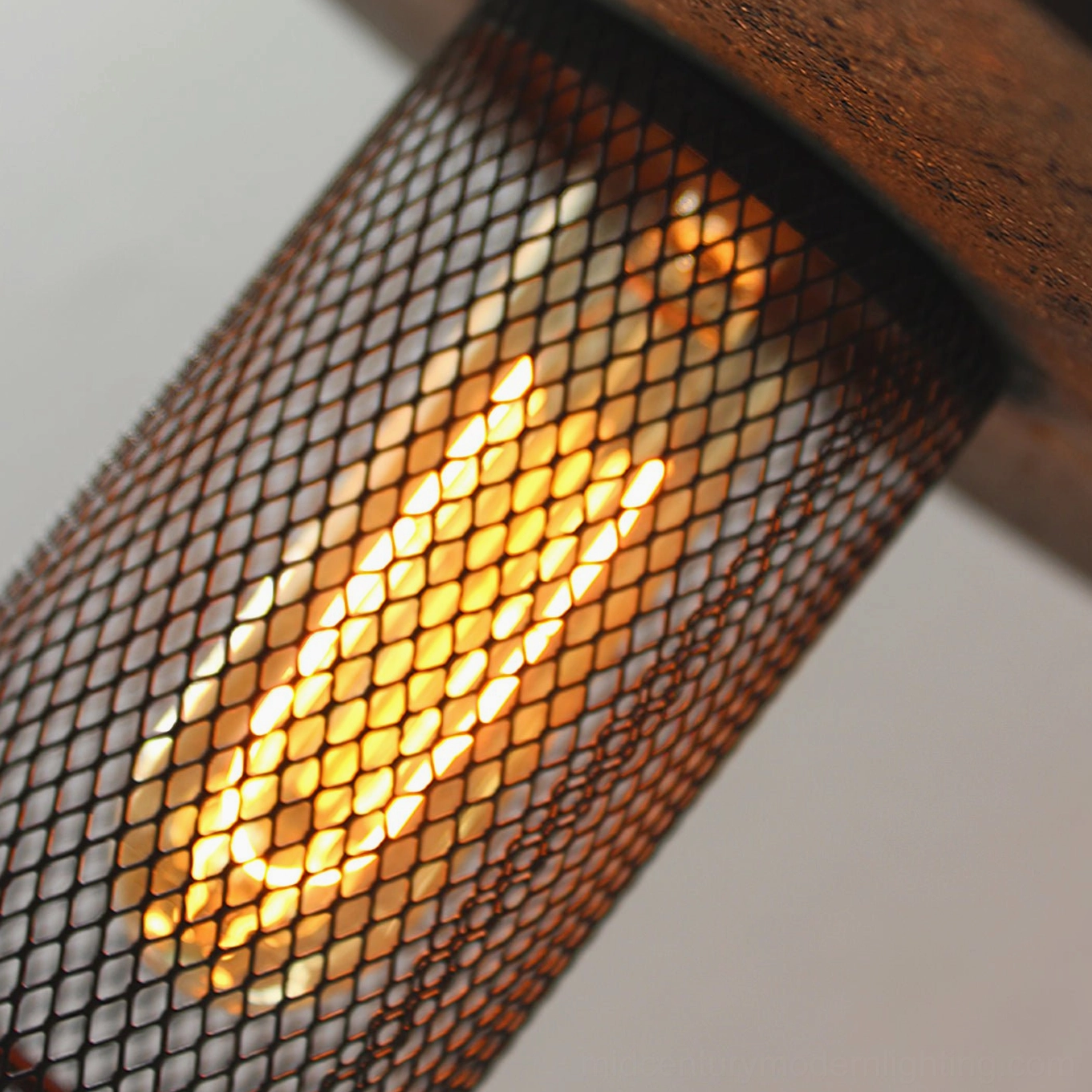 Macro close-up of black diamond mesh diffuser on Condo pendant showing warm incandescent light filtering through geometric pattern